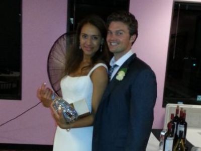 Alexis Rodman and Robert Bunfill are posing in their wedding dress, white gown and a black suit.